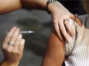 A patient gets a shot during a flu vaccine session.