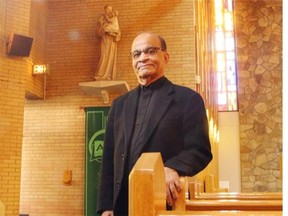 St. Anthony Parish Father Jack Pereira in the church with a statue of St. Anthony in the background.