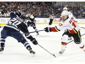 Blue Jackets defenceman Tim Erixon blocks a shot by Flames forward Lance Bouma, who wore a faceshield due to bashed up eye. The Flames lost 3-2.