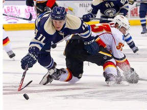 Blue Jackets forward Matt Calvert dives over Flames defenceman Rapheal Diaz in the second period of Columbus’ 3-2 victory.