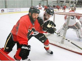 Brandon Bollig, left, jostles with Brett Kulak during a Calgary Flames training camp scrimmage on Friday.