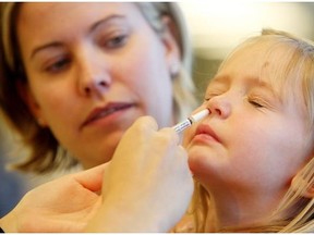 Caitlin Morris, 4, steels herself for the nasal vaccination at the Alberta Health Services flu clinic at the South Calgary Health Centre on Oct. 20, 2014.
