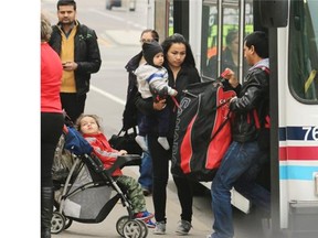 Calgarians displaced from their downtown homes arrive on city buses from hotels to return to their buildings on Thursday. Power was restored early Thursday to the blacked out area of downtown.