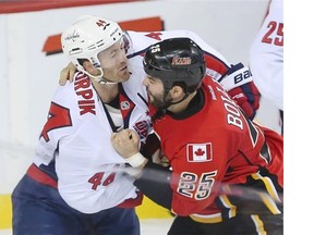 Calgary’s Brandon Bollig dukes it out with Washington’s Brooks Orpik during their Saturday night match.