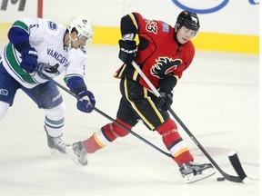 Calgary Flames centre Sam Bennett worked to keep the puck away from Vancouver Canucks defenceman Luca Sbisa during the first period in Thursday night’s exhibition game vs. Vancouver.