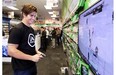 Calgary Flames centre Sean Monahan tries his hand at the new EA Sports NHL 15 game while meeting fans at EB Games in Mackenzie Towne on Tuesday.