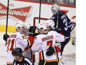 Calgary Flames defenceman TJ Brodie is congratulated by teammates for his goal against Winnipeg’s Ondrej Pavelec.