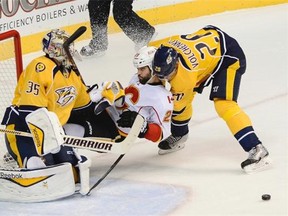 Calgary Flames left wing Brandon Bollig collides with Nashville Predators goalie Pekka Rinne after Rinne blocked his shot in the first period in Nashville on Tuesday night.