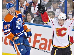 Calgary Flames’ Mason Raymond celebrates one of his three goals on the night as Edmonton Oilers forward Benoit Pouliot looks on during the third period on Thursday night. Calgary won 5-2 despite being badly outshot.