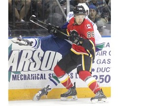 Calgary Flames prospect Josh Jooris slams Vancouver’s Evan McEneny into the boards during the Youngstars Tournament in Penticton, B.C. last month.