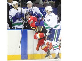 Calgary Flames prospect Patrick Seiloff is rammed into the Vancouver Canucks bench by Nicklas Jensen on Monday.