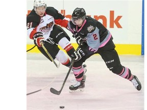 Calgary Hitmen rookie Jake Bean dekes around Prince George Cougars’ Jared Bathune during Sunday’s game at the Saddledome.