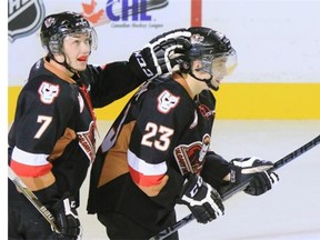 Calgary Hitmen rookie Taylor Sanheim gets a pat on the head from teammate Marshall Donald after scoring his first WHL goal against the Lethbridge Hurricanes and goaltender Zac Robidoux on Sunday.