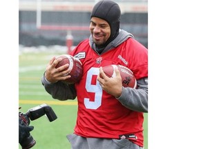 Calgary Stampeders running back Jon Cornish poses for photos after a cold, snowy practice in Calgary on Tuesday.