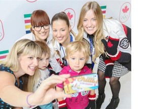 Chelsea Thiessen with her two sons, Jayce, age 3, white top, and Eben, age 2 pink top, take a selfie at Chinook Centre on Thursday with the Olympic freestyle skiing Dufour-Lapointe sisters, Maxime, left, Chloe, and Justine, who are the new Hudson’s Bay Red Mitten ambassadors.