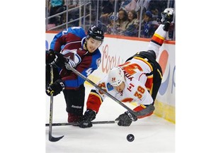 Colorado Avalanche center Samuel Henley and Calgary Flames defenceman Nolan Yonkman go after the puck during the first period of a preseason NHL game on Sunday.