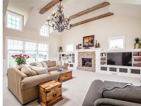 Courtesy of Gallaghers Homes The great room has a vaulted ceiling and a fireplace surrounded in brick and flanked by built-in shelves. This space is bright with soaring windows on both ends.