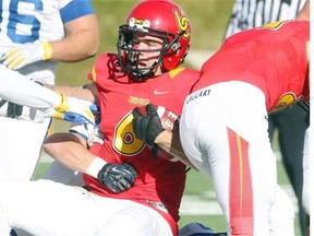 Dinos receiver Jake Harty is taken down in the first half as the University of Calgary Dinos football team played host to the University of BC Thunderbirds on Octpber 25, 2014.