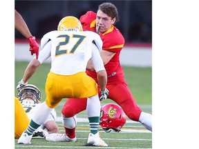 Dinos running back Quentin Chown loses his helmet but keeps fighting for yardage in the season opener against the U of A Golden Bears, which is Calgary’s opponent Saturday.