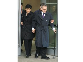 Doug de Grood, centre, and his wife Susan leave the Calgary Courts Centre on Friday morning following hearing for their son, Matthew de Grood, accused in the Brentwood slayings.