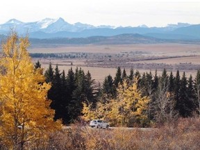 A car drives along Springbank Road into the area that is ground zero for the Springbank dam and reservoir.