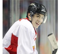 Flames rookie Johnny Gaudreau smiles from the bench during practice at the Saddledome on Wednesday. The rookie is coming off one of his best games of the season.