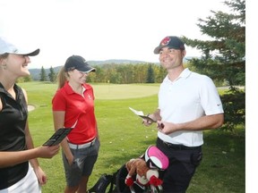 Golfers Courtney Schubert and Ali Cronkwright receive tips from University of Calgary golf coach Thomas Schupp at Priddis Greens Golf and Country Club earlier this week.