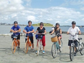 A guided bike tour is a great way to see Halifax. The Olsen family are pictured on the Halifax Harbour with Georges Island National Historic Site of Canada in the background. The island was an important military site and also served as a prison during the Acadian Deportation (1755-1763). 
 Courtesy Debbie Olsen