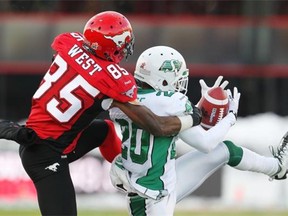 Halfback Terrell Maze of the Saskatchewan Roughriders steals an interception away from Calgary Stampeder receiver Joe West during the first half of the 2013 CFL West Final at McMahon Stadium last November. The Stamps no doubt have that loss in mind when planning out the stretch run of the 2014 season.