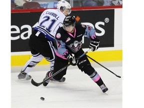 Hitmen defenceman Ben Thomas fights for possession of the puck against Victoria Royal Austin Carroll during WHL action at the Saddledome Friday night. The Hitmen lost the game 3-2.