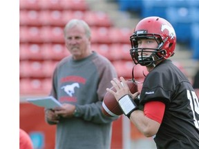 Injured Stampeders quarterback Bo Levi Mitchell throws alongside coach John Hufnagel during practice on Wednesday.