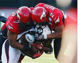 Junior Turner and teammate Deron Mayo of the Calgary Stampeders tackle Chevon Walker of the Ottawa RedBlacks during a game last month. Turner will be counted on heavily with Calgary’s depleted defensive line.