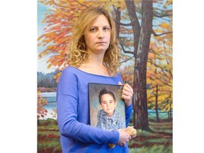 Layale Khalifeh holds a picture of her son, Jad, age 7, and his favourite stuffed lion in Calgary on Thursday, Sept. 11, 2014.