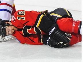 Matt Stajan of the Calgary Flames grimaces in pain after being hurt during play against the Montreal Canadiens on Tuesday. He will be out a minimum of six weeks after sustaining knee damage.