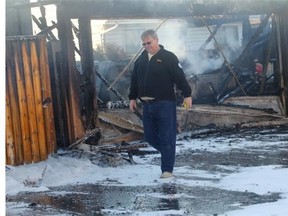 Mike Gemsa surveys the damage to the home, truck and garage of his next door neighbour at 62 Aberdare Crescent following a fire Thursday afternoon October 2, 2014.