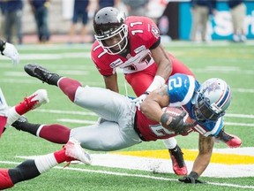 Montreal Alouettes’ Brandon Whitaker dives for yardage as Calgary Stampeders’ Joshua Bell moves in for a tackle during their match on Sunday.