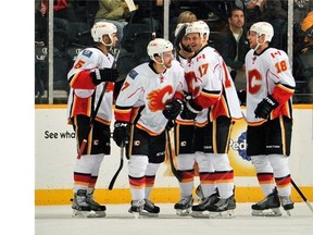 Mark Giordano #5, Lance Bouma #17, and Matt Stajan #18 of the Calgary Flames congratulate teammate TJ Brodie #7 on scoring a goal against the Nashville Predators on Tuesday night.