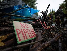 A camp setup by protesters is marked with a sign and tree branches at the entrance to a trail on Burnaby Mountain where work is being done by Kinder Morgan in preparation for the Trans Mountain Pipeline expansion project in Burnaby.