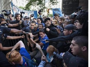 Protestors and police wrestle near a barricade on the corner of Wall Street and Broadway during a march demanding action on climate change and corporate greed, Monday, Sept. 22, 2014, a day after a huge climate march in New York. (AP Photo/John Minchillo)