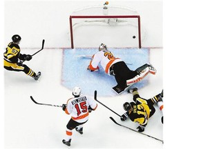 Pittsburgh Penguins' Marcel Goc scores a goal behind Philadelphia Flyers goalie Ray Emery on Wednesday. Reader appreciates that O Canada was sung at game.