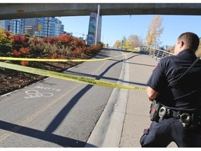 Police contain the scene of a stabbing on the pathway along Riverfront Avenue in downtown Calgary on Saturday afternoon. One man was taken to hospital in life-threatening condition.