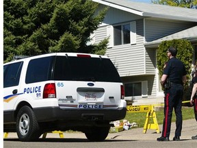 Police investigate the scene of a triple murder in Medicine Hat in 2006. The woman convicted of murdering her parents and eight-year-old brother when she was 12 years old has been granted more freedom, with her sentence due to expire in May 2015.