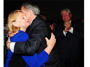 Jim Prentice hug his wife Karen as Dave Hancock looks on as the results of his 77% victory are announced at the PCAA in Edmonton, September 6, 2014.