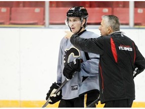 Raphael Diaz listens to coach Calgary Flames head coach Bob Hartley at practice on Monday. He signed a one-year deal with the Flames after an impressive training camp performance as a walk-on free-agent.