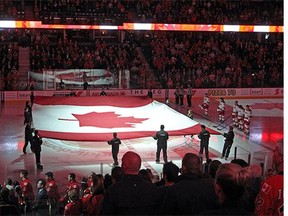 A giant flag was held at centre ice as a tribute to the fallen soldier Col. Nathan Cirillo prior to the game between the Calgary Flames and the Carolina Hurricanes in NHL action at the Scotiabank Saddledome on October 23, 2014.