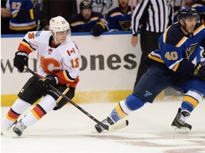 St. Louis Blues' Maxim Lapierre (40) gets by Calgary Flames' Johnny Gaudreau (13). (AP Photo/Bill Boyce)