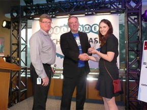 Emily Hicks, right, director at FREDsense Technologies, receives the Pitch Perfect grand prize from Peter Garrett, centre, president of Innovate Calgary, and Peter Calverley, a judge at the Tech Showcase 2014.