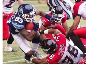Toronto Argonauts’ Terrell Sinkfield is tackled by Calgary Stampeders’ Glenn Love during a July meeting between the two teams.