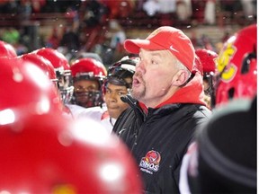 University of Calgary Dinos head coach Blake Nill, centre, speaks to the players after losing the Vanier Cup to Laval University Rouge et Or Saturday, November 23, 2013 in Quebec City. THE CANADIAN PRESS/Jacques Boissinot