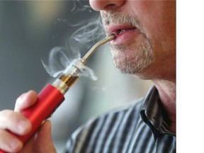 A user in Calgary takes a puff from an e-cigarette on Sept. 30, 2014.